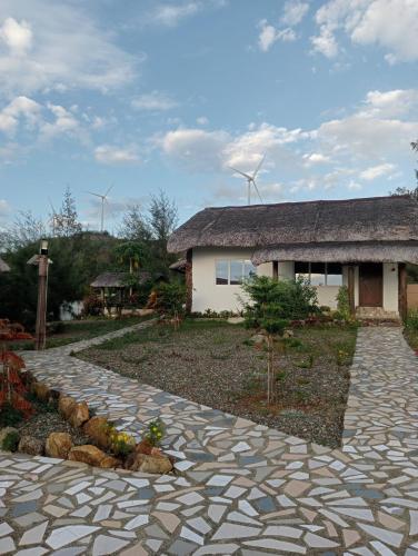 a stone walkway in front of a house with wind turbines at Bregil Villas in Pagudpud