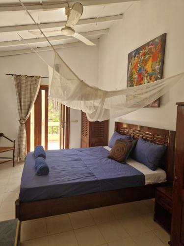 a bedroom with a bed with a mosquito net at Beach House in Saly Portudal