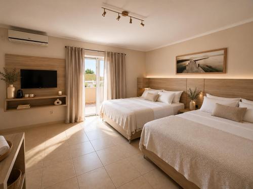 a hotel room with two beds and a television at Villa Illyria in Donji Štoj