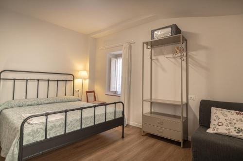 a bedroom with a bed and a shelf and a chair at Al Cantuccio Affittacamere in Assisi