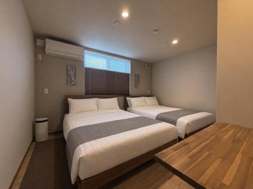a bedroom with two beds and a window at Koyuki Kimobetsu in Abuta