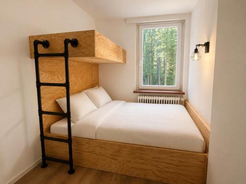 a small bedroom with a bunk bed and a window at Der Sunderhof in Seevetal