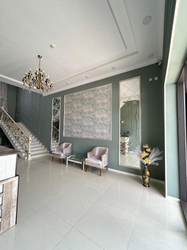 a living room with two chairs and a staircase at Comfort Hotel in Türkistan