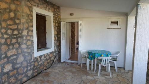 une terrasse avec une table et des chaises dans une maison dans l'établissement Studio Apartment Bosko, à Novalja