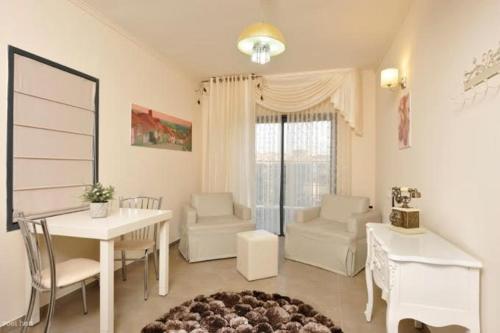 a living room with a table and chairs and a dining room at Achuza Bamarom in Safed