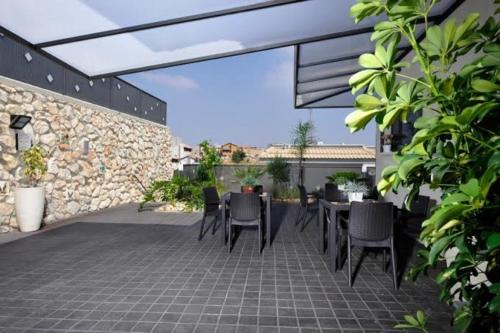 a patio with a table and chairs and a stone wall at Achuza Bamarom in Safed