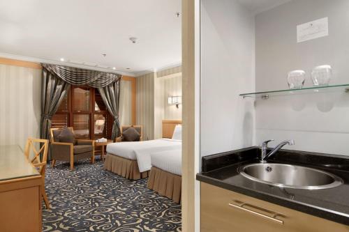 um quarto de hotel com uma cama e um lavatório em Makkah Towers em Meca