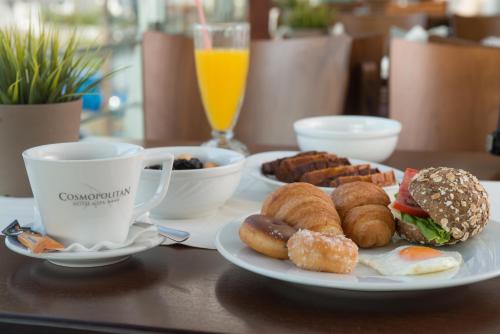a table with a plate of food and a cup of coffee at Cosmopolitan Hotel in Paralia Katerinis