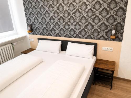 ein Bett mit zwei Kissen darauf in einem Zimmer in der Unterkunft Hotel Constantin Trier in Trier