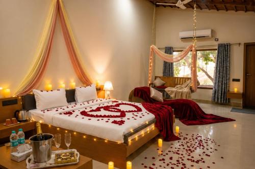 a bedroom with a bed with a heart made out of roses at Shunyata Eco Resort Junagadh in Vadal
