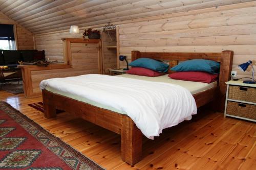 a bedroom with a bed in a log cabin at Hosting Orchard in Beit Hillel