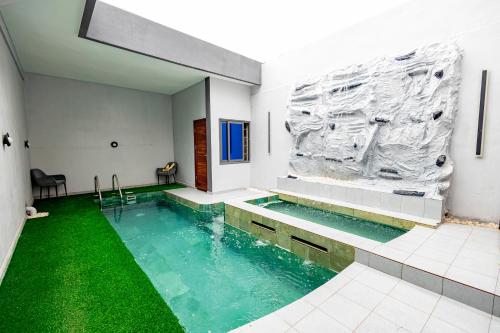 a swimming pool with green flooring in a building at Luz RÉSIDENCE in Abomey-Calavi