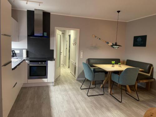 a kitchen and dining room with a table and chairs at Ferienwohnung Sundkieker Fehmarn in Fehmarn