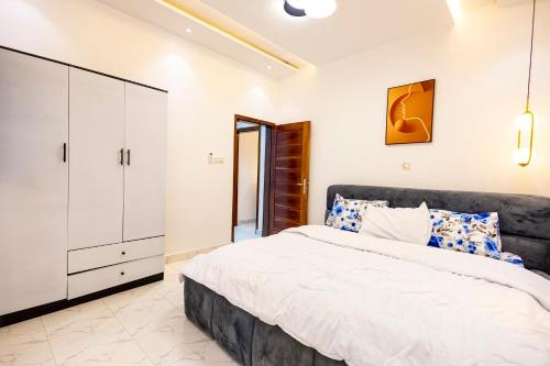 a bedroom with a large bed and a white cabinet at Luz RÉSIDENCE in Abomey-Calavi