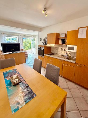 a kitchen with a wooden table and a dining room at Schnütgenhof Appartements in Attendorn