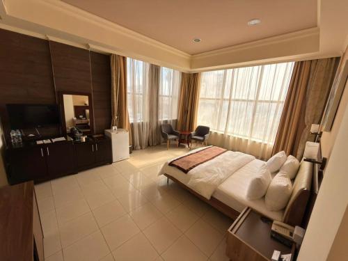 a bedroom with a bed and a desk and a chair at Royal Grand Hotel in Monrovia