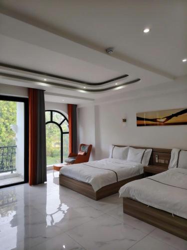 a bedroom with two beds and a chair in it at Furaton Hotel in Ðức Hòa