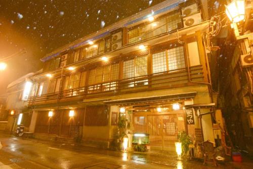 a building on a street at night in the snow at Senshinkan Matsuya in Yamanouchi