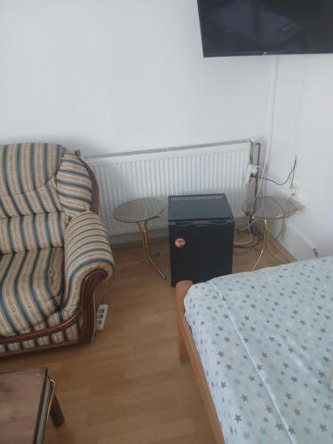 a room with a couch and a chair and a table at Aleksinac Centar Two-Bedroom Apartment in Aleksinac