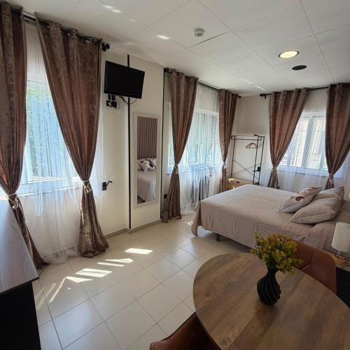 a bedroom with a bed and a table and windows at Residencia Porta Nova in Ferrol