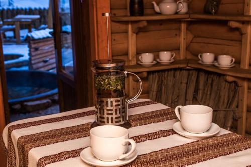 a vase on a table with cups and saucers at Karpaty Migovo in Migovo