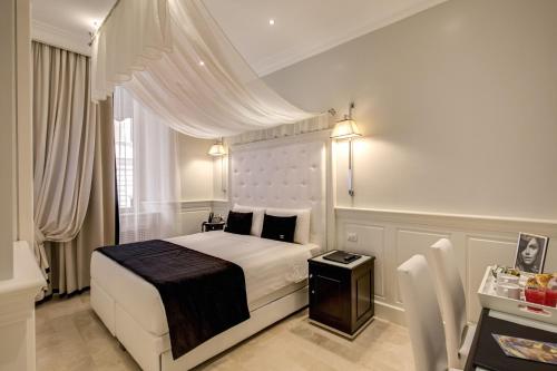 a bedroom with a white bed with a black blanket at Hotel Tito in Rome