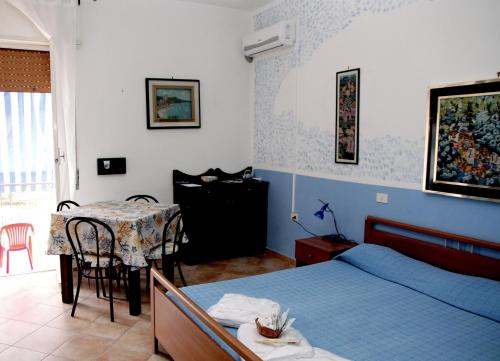 a bedroom with a bed and a table and a table and chairs at Mare e Coccole in Caprioli