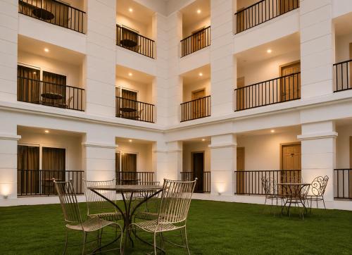 a building with chairs and a table in the courtyard at Hotel The Golden Sands, Located on Calangute Main Road in Calangute