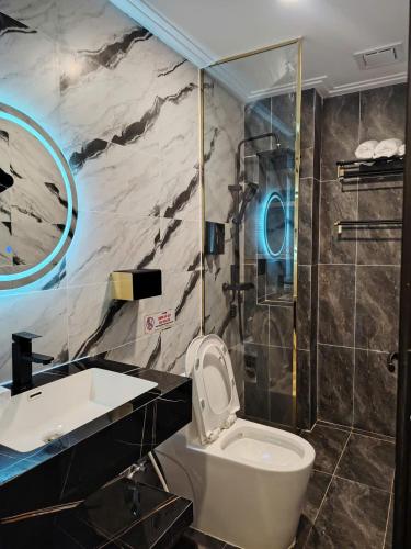 a bathroom with a sink and a toilet and a shower at Furaton Hotel in Ðức Hòa