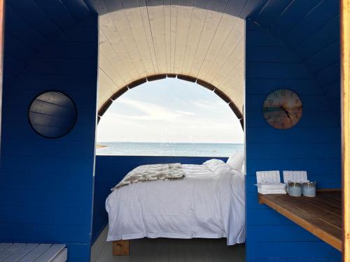 a blue room with a bed and a clock at Glamping Pod in Milltown Malbay