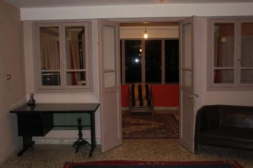 a living room with a table and two windows at Bauhaus Motel in Bcharré