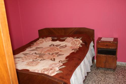 a bed in a room with a pink wall at Bauhaus Motel in Bcharré