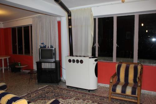 a living room with a stove and a tv at Bauhaus Motel in Bcharré