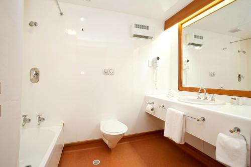 ein Badezimmer mit einem Waschbecken, einem WC und einem Spiegel in der Unterkunft Distinction Mackenzie Country Hotel in Twizel