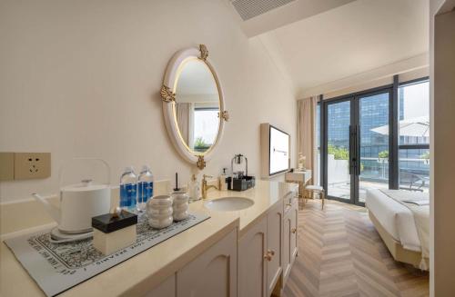 a white bathroom with a sink and a mirror at Secluded Comfort City Resort Hotel in Hangzhou