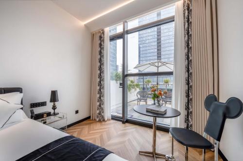 a bedroom with a bed and a table and a window at Secluded Comfort City Resort Hotel in Hangzhou