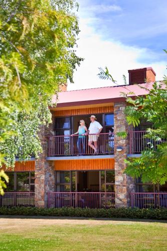 two people standing on a balcony of a building at Distinction Mackenzie Country Hotel in Twizel