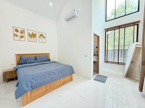 a bedroom with a bed in a white room at Nook Villa in Ban Khlong Mae Nam