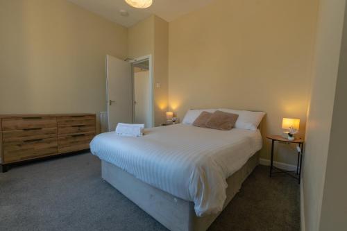 a bedroom with a bed and a dresser and two lamps at Edinburgh Shore Apartments in Edinburgh