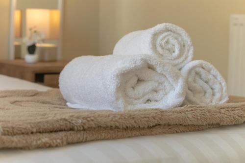 a pile of towels sitting on top of a bed at Edinburgh Shore Apartments in Edinburgh