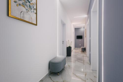 a hallway with a blue chair in a white room at APART-HOTEL PRESiDENT 2 in Ulcinj