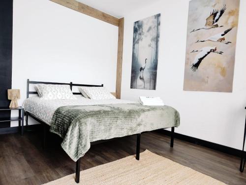a bedroom with a bed and two paintings on the wall at Weekendowo Miejsce i Czas Agroturystyka in Wyszogród