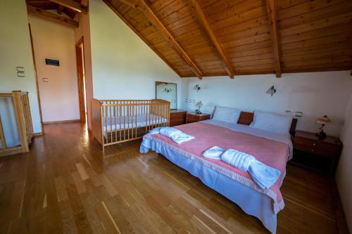 a bedroom with a large bed and a crib at Palmyra Beachfront Studios in Nydri
