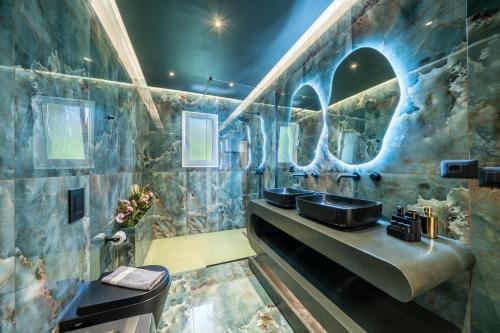 a bathroom with two sinks and two mirrors at Popi's apartment in Argostoli