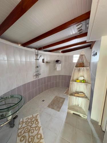 a bathroom with a glass table and a glass shelf at Gite d'Arles "Villa Doudou" in Le Moule