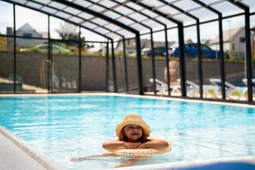 a girl in a straw hat in a swimming pool at BELMAR Park Resort in Władysławowo