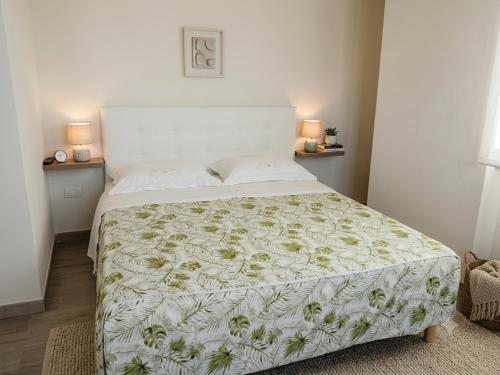 a bedroom with a bed with a green and white bedspread at Andasì in Pachino