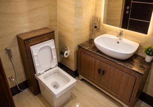 a bathroom with a white toilet and a sink at Aneks Ibro Hotel, Wuse Zone 5, Abuja in Abuja