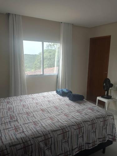 a bedroom with a bed and a large window at Residência completa e com garagem in Garanhuns