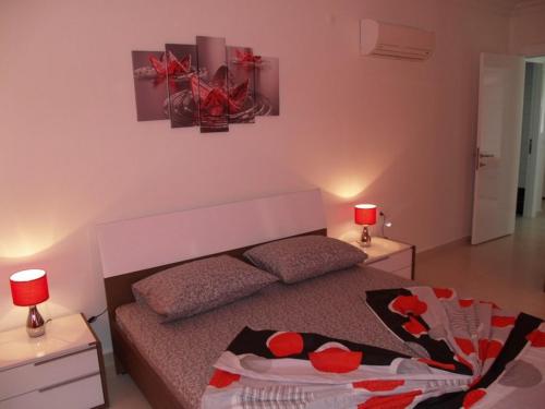 een slaapkamer met een bed en 2 tafels met lampen bij Orion Resort Zara 20 in Avsallar